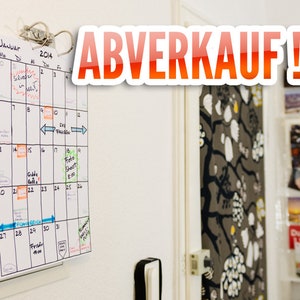 Könnte beinhalten: Ein weißer Kalender mit dem Wort "JANUAR" und dem Jahr "2014" oben. Der Kalender hängt an einer weißen Wand mit einem roten und weißen Schild, auf dem "ABVERKAUF!!" steht.