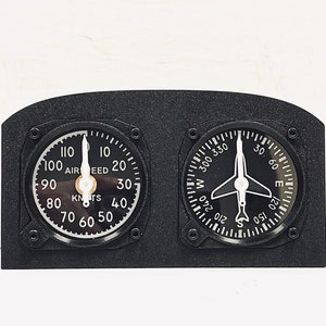May include: A black panel with two round gauges. The left gauge is an airspeed indicator with a white needle pointing to 100 knots. The right gauge is a compass with a white airplane symbol pointing to north.