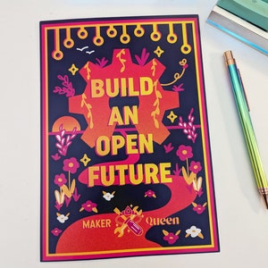 以下が含まれることがあります： 「BUILD AN OPEN FUTURE」の文字が黄色とオレンジ色で描かれた長方形のプリント。赤とオレンジの歯車デザインと花の要素で囲まれています。プリントには「MAKER Queen」の文字も含まれており、濃い青色の背景が使用されています。