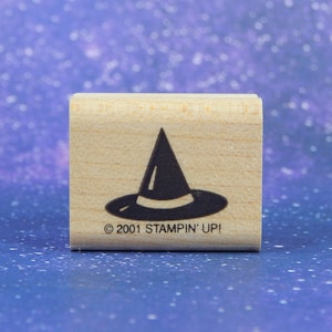 May include: A wooden rubber stamp with a black silhouette of a witch's hat. The stamp reads "© 2001 STAMPIN' UP!"