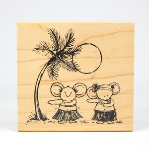 Könnte beinhalten: Ein Holzstempel mit einer Schwarzweißillustration von zwei Mäusen, die Grasröcke und Blumenketten tragen und unter einer Palme mit einer Sonne dahinter tanzen.