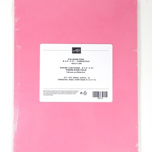 May include: A pack of polished pink cardstock paper, measuring 21.6 x 27.9 cm, wrapped in clear plastic. The label reads "Polished Pink" and "Cardstock". The paper is made in the USA.