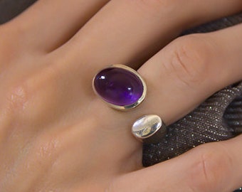 Open silver ring with beautiful purple amethyst oval stone on top of it. A perfect birthstone cocktail ring for women