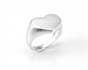 A silver romantic heart-shaped pinkie signet ring. The couple's initials can be engraved on it