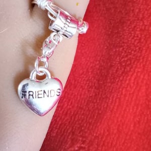 Here&#39;s a gift to that special friend in this charm ring. Silver heart with the word &quot;friends&quot; engraved in it.