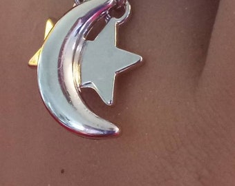 Two stars and a single moon are dangling from a deep blue ring base on this charm ring