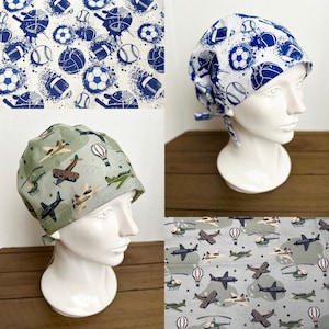 May include: Three different patterned scrub hats. The first hat has a white background with blue and black sports-themed designs. The second hat has a white background with blue and black aeroplane designs. The third hat has a green background with black and brown aeroplane designs.
