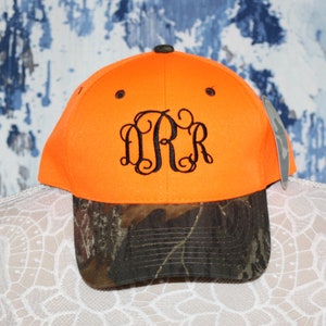 May include: Orange and camouflage baseball cap with a black embroidered monogram "D.R.R."