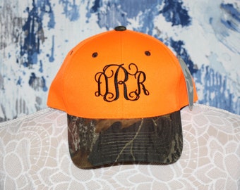 May include: Orange and camouflage baseball cap with a black embroidered monogram "D.R.R."