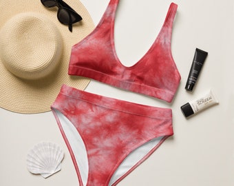 Op de afbeelding: Een rood en wit tie-dye bikini top en broekje. De bikini top heeft een V-hals en het broekje is hoog getailleerd. De bikini ligt op een witte achtergrond.