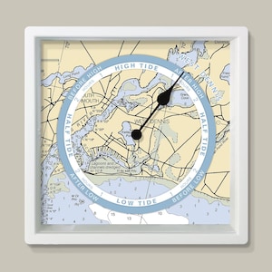 May include: A square wall clock with a white frame. The clock face features a nautical chart of West Dennis, Massachusetts, with a blue tide dial. Black clock hands indicate the time. The clock displays "High Tide" and "Low Tide".