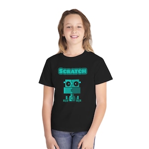 May include: A black short-sleeved t-shirt featuring a teal graphic of a blocky robot character with the word SCRATCH printed in a bold teal font above the robot. The design is centered on the chest of the garment, showcasing a simple, geometric style.