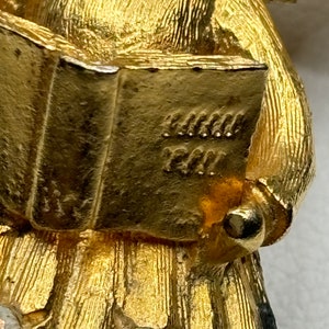 Pu&ograve; includere: Figurina di angelo dorata che tiene un libro con l'iscrizione "Grandma's Girl". L'angelo indossa un abito fluido con strass.