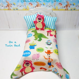 May include: Toy Story dollhouse bedding set with a white background and a colorful print featuring characters like Woody, Buzz Lightyear, and Rex. The bedding set includes a pillow and a comforter with a twin bed size.