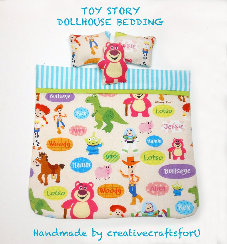 May include: Toy Story dollhouse bedding set with a pink and white patterned duvet cover and two pillows. The duvet cover features characters from the Toy Story movies, including Woody, Buzz Lightyear, Jessie, and Lotso. The pillows are white with a brown border and feature the characters Jessie and Lotso.