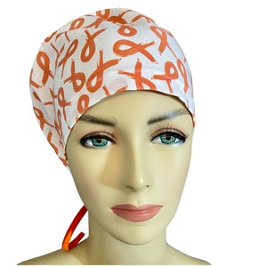 May include: White surgical scrub cap with a repeating pattern of orange awareness ribbons. The cap is tied in the back with orange ties. The cap is designed to be worn in a medical setting.