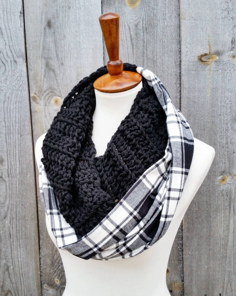 May include: A black crocheted infinity scarf with a white and black plaid fabric lining.