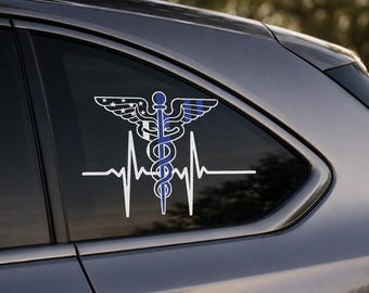 May include: A white and blue vinyl decal applied to a car window. The design features a medical caduceus symbol integrated with a heartbeat EKG line. The left wing of the caduceus displays a star pattern, while a thin blue line runs vertically.