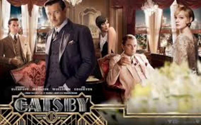 May include: A group of people in a lavishly decorated room, dressed in 1920s attire. The room features a large window with a view of a city skyline. The word "GATSBY" is prominently displayed in the foreground.