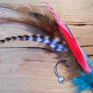 May include: A turquoise, pink, and red feather earring with a silver hook and bead.