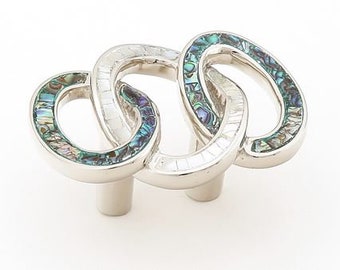 May include: A silver cabinet knob with an interlocking design. The oval-shaped links are inlaid with iridescent abalone shell, creating a colorful, textured surface. The knob has a polished finish and a cylindrical base.