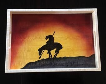 May include: A wooden serving tray with a white frame and a painted sunset scene with a silhouette of a Native American on horseback.