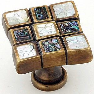 May include: Square cabinet knob with a brass finish and a mosaic of iridescent mother-of-pearl tiles.