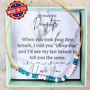 May include: A gold chain bracelet with turquoise and pink beads spelling out "I Love You" in Morse code. The bracelet comes in a small box with a message that reads "My beautiful Daughter. When you took your first breath, I told you "I love you" and I'd use my last breath to tell you the same."