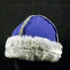 May include: A blue and grey winter hat with a faux fur brim.