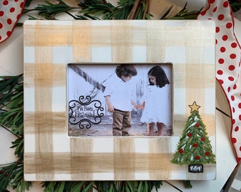 May include: White and gold buffalo plaid picture frame with a photo of two children inside. The frame has a painted Christmas tree on the right side and the text "I've Been Framed" on the left side.