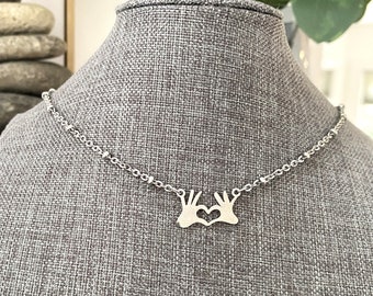 Stainless steel HEART & HANDS NECKLACE on a satellite chain - hands charm 3/4" wide x 3/8" tall. all stainless steel, non tarnish