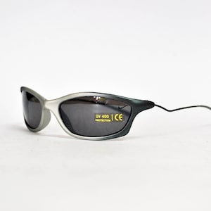 May include: Gray and black sunglasses with a thin black frame and gray lenses. The sunglasses have "UV 400 PROTECTION CE" printed on the right lens.