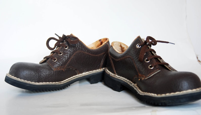 K&ouml;nnte beinhalten: Ein Paar braune Lederschn&uuml;rschuhe mit wei&szlig;en N&auml;hten um die Sohle.