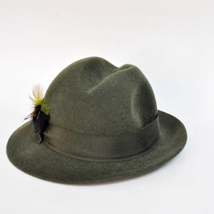 May include: A green felt fedora hat with a black and green feather accent.