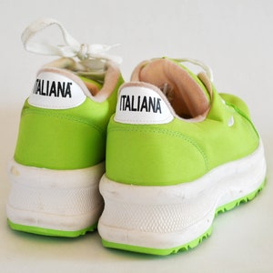 May include: A pair of lime green canvas sneakers with white soles and the word "ITALIANA" printed on the side of each shoe.