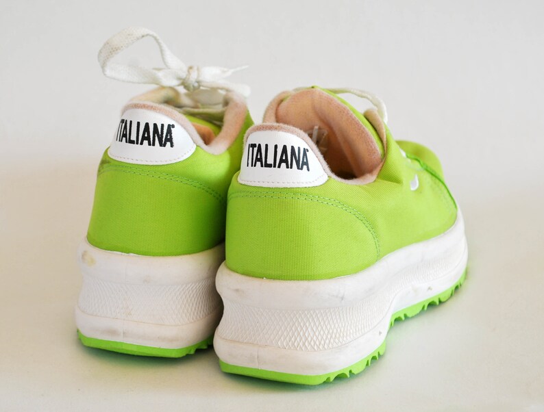 May include: A pair of lime green canvas sneakers with white soles and the word "ITALIANA" printed on the side of each shoe.