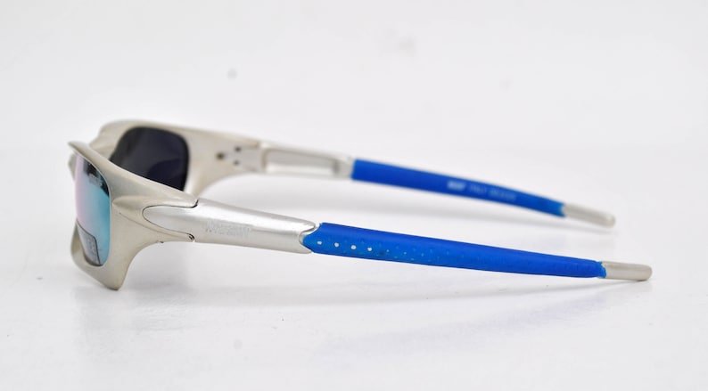 May include: Silver sunglasses with blue rubber arms and mirrored lenses.
