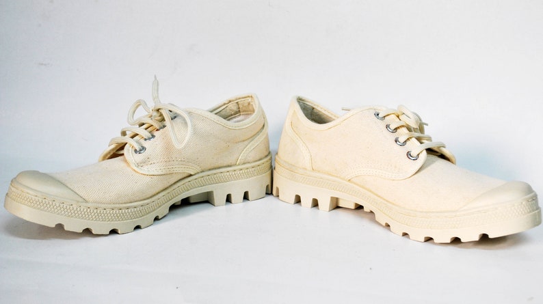 May include: A pair of off-white canvas shoes with thick white rubber soles and laces.