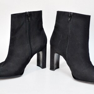 May include: A pair of black ankle boots with a square toe and a block heel.