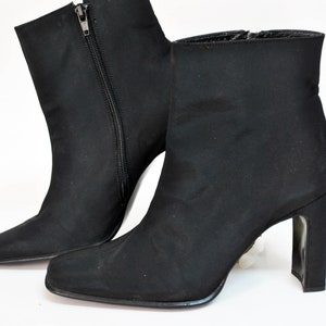 May include: A pair of black ankle boots with a pointed toe and a block heel.