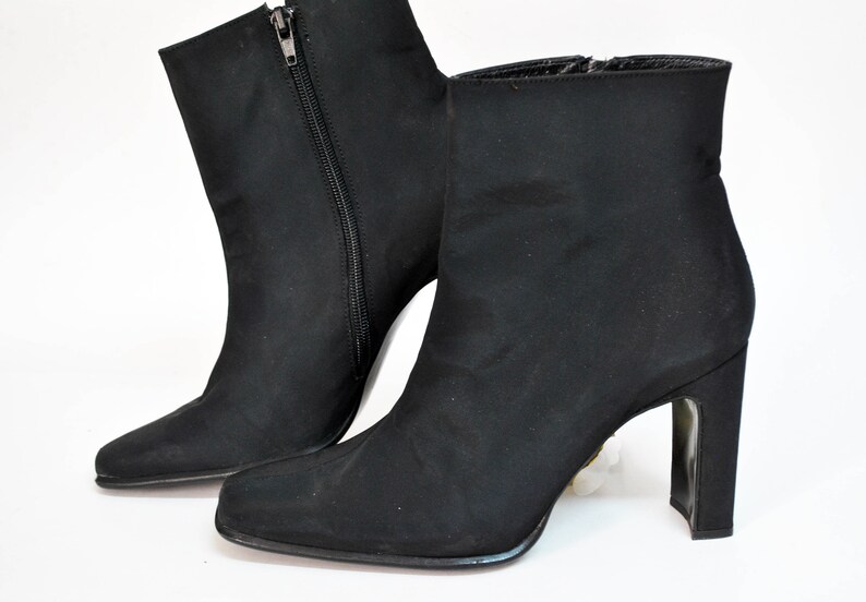 May include: A pair of black ankle boots with a pointed toe and a block heel.