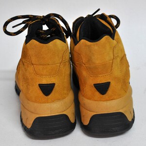 May include: A pair of brown suede hiking boots with black laces and a black rubber sole.