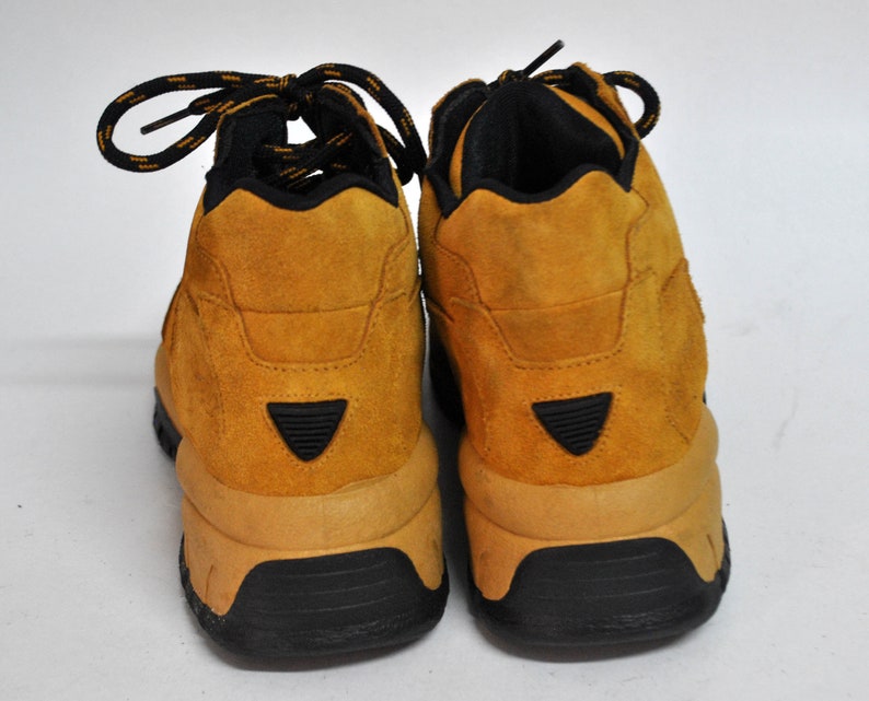 May include: A pair of brown suede hiking boots with black laces and a black rubber sole.