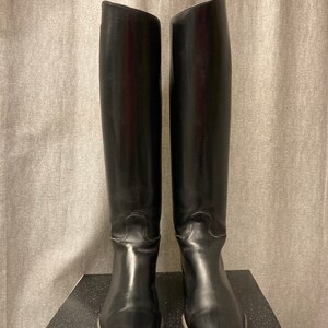 May include: A pair of black leather riding boots with a tall shaft and a pointed toe.