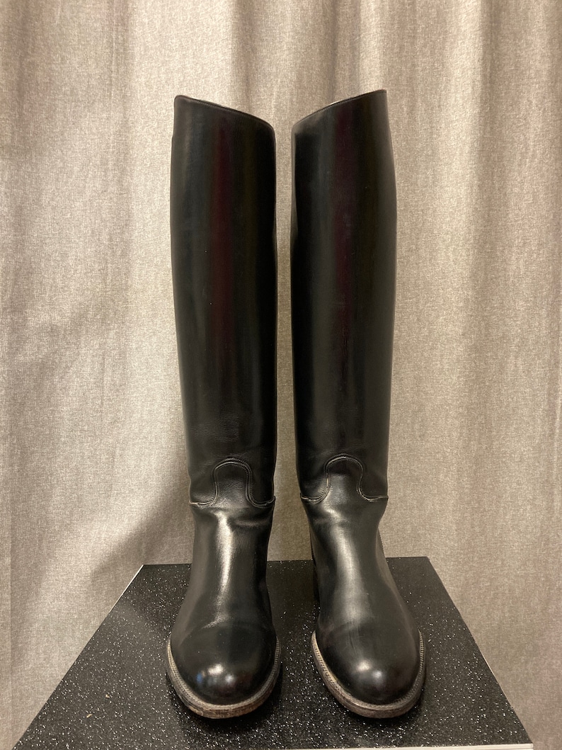 May include: A pair of black leather riding boots with a tall shaft and a pointed toe.