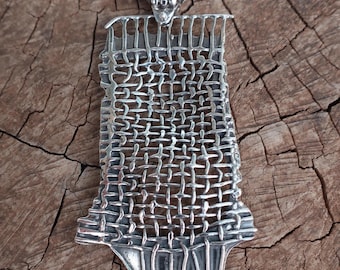 May include: A silver pendant necklace featuring a rectangular, woven metal mesh design. The top of the pendant has a triangular bail, and the bottom edge is decorated with five small, round, dark red garnet gemstones set in silver bezels.