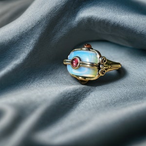 a ring sitting on top of a blue cloth