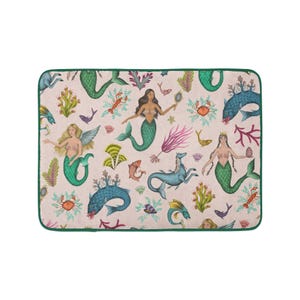 Può includere: Un tappeto rosa e verde con sirene, cavallucci marini, pesci e granchi. Il tappeto ha un bordo verde.
