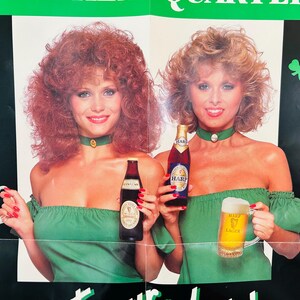 May include: Vintage poster showing two women in green dresses, holding bottles and tankards of beer. The poster has a green and black background with shamrock cutouts. The bottles and tankards display the Guinness and Harp logos.