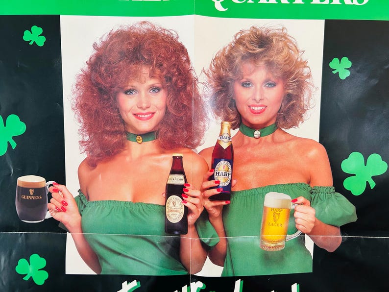 May include: Vintage poster showing two women in green dresses, holding bottles and tankards of beer. The poster has a green and black background with shamrock cutouts. The bottles and tankards display the Guinness and Harp logos.